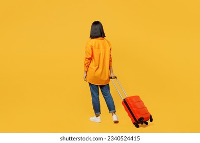 Back view young woman wear summer casual clothes walk go with suitcase bag isolated on plain yellow background. Tourist travel abroad in free spare time rest getaway. Air flight trip journey concept - Powered by Shutterstock