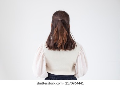 Back View Of A Young Woman Working In An Office With Her Hair Tied Up