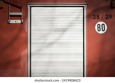 The back wall of an old fire engine, with silver shutters and a sign with the speed limit 80.