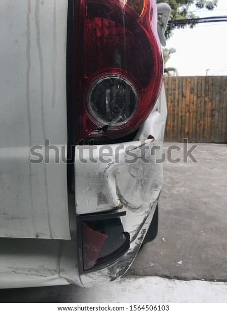Back of white car get damaged from accident on\
the road. Vehicle bumper dent broken by car crash. Road accidents\
and car insurance concept