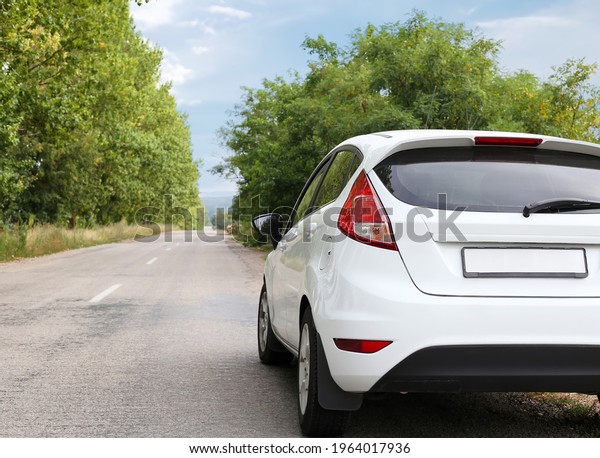 The\
back of a white car on the track in the direction of the path. Car\
on the road in a forest area. Travel by small\
car