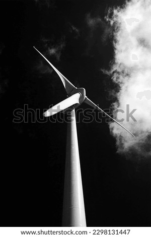 Back and white minimalist composition with wind turbine, cloud and dark sky