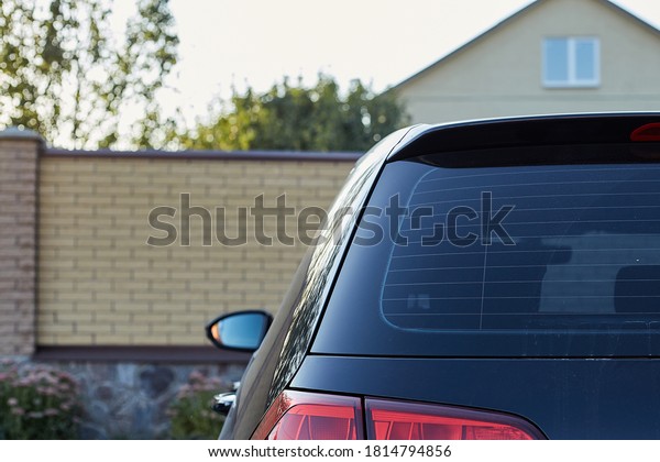 Back window of a car\
parked on the street in summer sunny day, rear view. Mock-up for\
sticker or decals
