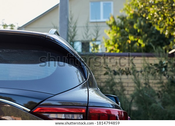 Back window of grey\
car parked on the street in summer sunny day, rear view. Mock-up\
for sticker or decals