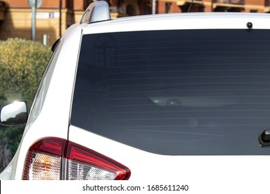Back window of a white car parked on the street near houses, rear view. Mock-up for sticker or decals - Shutterstock ID 1685611240