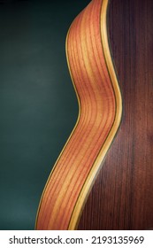 Back Of Wooden Guitar Against Green Background￼