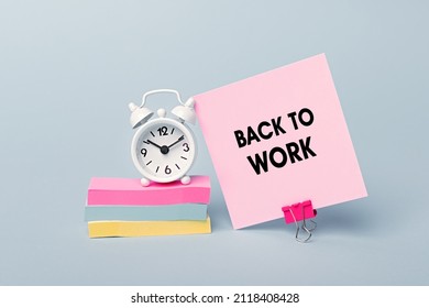 Back To Work - Concept Of Text On Pink Sticky Note. Closeup Of A Personal Agenda. Alarm Clock And Colorful Stickers Light Blue Background