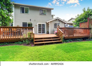 Back Yard House Exterior With Spacious Wooden Deck With Patio Area And Attached Pergola. Northwest, USA