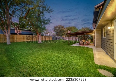 A back yard with a patio at sunset