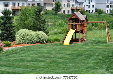 Back Yard Wooden Swing Set on Green Lawn