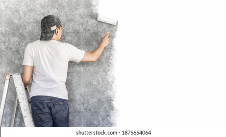 Back Of Young Asian Man On Ladder Painting Interior Cement Wall With Paint Roller For Home Renovation Background