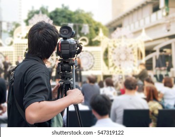 Back Of Young Cameraman Using A Professional Camcorder Outdoor  Filming Music Show Or Mini Concert With Blur Background, Bangkok, Thailand