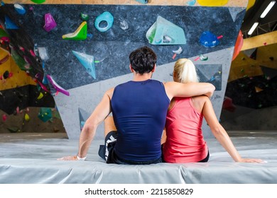 Back Of Young Couple Preparing To Bouldering Climbing Up The Wall Together While Resting Together.Horizontl Image