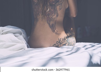 the back of a young girl with a tattoo . Tanned beautiful girl with a tattoo on the entire back