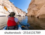 Back of young happy girl kayaking on lake powell with paddle and kayak and life vest on Antelope slot canyon in Arizona during summer