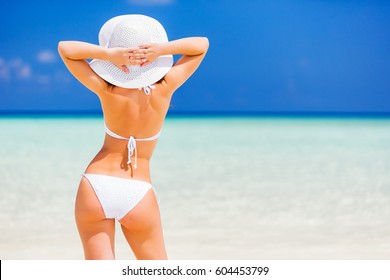 Back Of Young Woman In Bikini Standing On The Beach