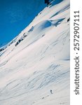 A backcountry skier descends a steep slope in the snow