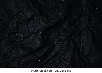 A backdrop of crinkled black paper, enhanced by holographic speckles that catch the light, creating a multicolored, starry-night effect.