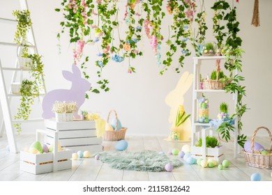 Backdrop for photo studio with easter design interior decorations for kids and family photo sessions. Plants, flowers, wooden rabbit, colorful dyed eggs, baskets.  - Shutterstock ID 2115812642