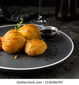 Backed Accordion Potatoes And Vegetables And Sauce In The Dark Plate 