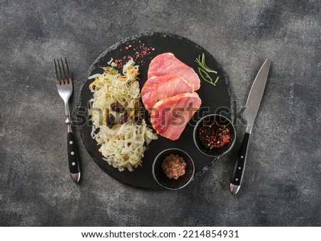 Backed Kasseler pork steak with sauerkraut. Smoked pork lion. Sliced smoked pork chop on wooden board. Top view.
