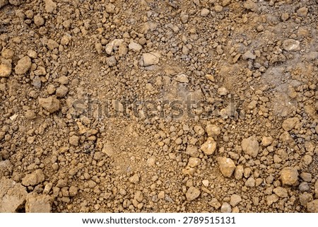Backfilled ground over repaired utility trench with compacted soil and construction debris after emergency pipeline works, concept of site restoration