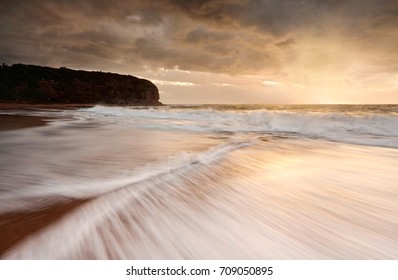 The backflow of two waves zip together.  Exposure showing  motion of the water and illusion of painted affect in the other waves.  Moody skies above drizzle occasionally 