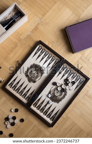 Backgammon board on the floor surrounded by props 