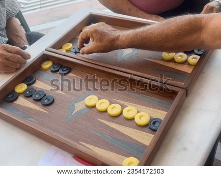 Backgammon, closeup hands of man playing greek style backgammon in Greece. playing board games. leisure activities with friends