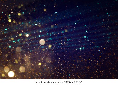 Background Of Abstract Blue, Gold And Black Glitter Lights. Defocused