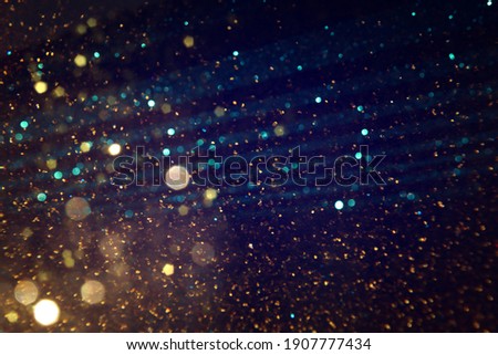 background of abstract blue, gold and black glitter lights. defocused