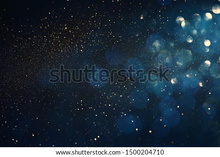 background of abstract glitter lights. blue, gold and black. de focused