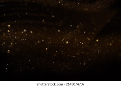 background of abstract glitter lights. gold and black. de focused