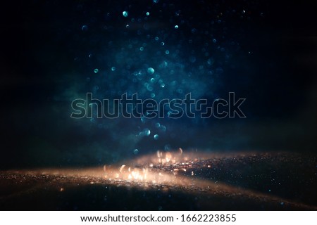 background of abstract glitter lights. gold, blue and black. de focused