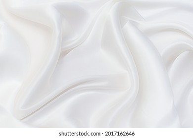Background abstract texture of natural light color fabric. Fabric texture of natural cotton or linen, silk or satin, wool or jersey textile material. Luxurious white canvas background.