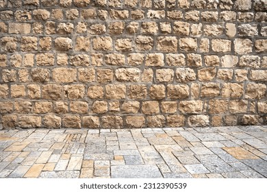Background with an ancient brick wall and pavement of old city of Jerusalem, Israel