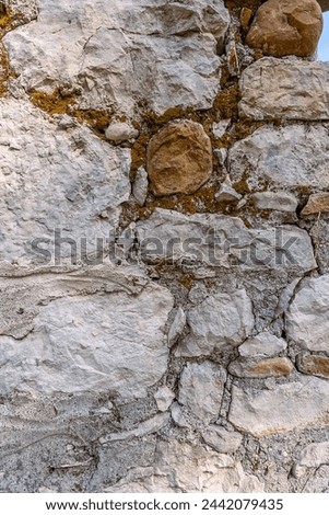 Background. An ancient wall made of archaically processed stone. The wall of the ancient building is made of stones.
