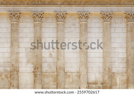 Background of antique Roman temple wall with Corinthian columns of Maison Carree (square house), ancient building in Nimes, Provence, southern France