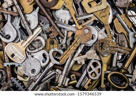Background of assorted old multi-colored metal antique keys of different shapes. Home security concept.