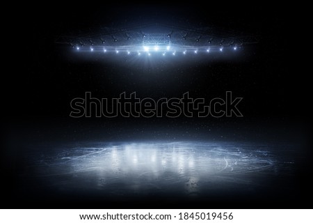 Background. Beautiful empty winter background and empty ice rink with lights. Spotlight shines on the rink. Bright lighting with spotlights. Isolated in black