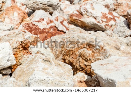 Background of big light rusty stones. Rocky coast.