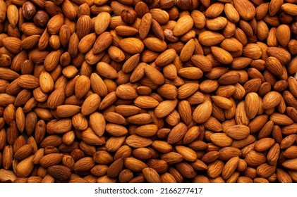 Background Of Big Raw Peeled Almonds Situated Arbitrarily. High Quality Photo