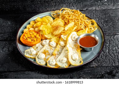 Background Black Burnt Charred Wood, Structure, Flat Plate, Snack For Alcohol, Onion Rings, Croutons, Peanuts Nuts, Potato Chips, Sauce