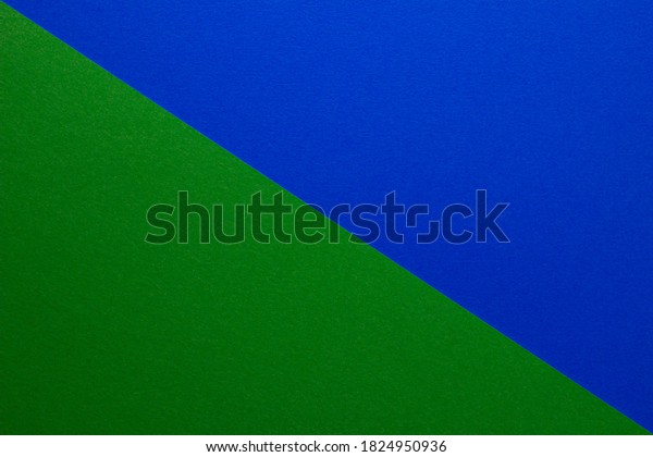 Background of\
blue and green paper divided diagonally. Sheets of blank green and\
blue paper with fine texture, close\
up.