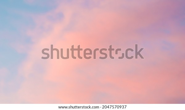 Background of\
blue sky with pale pink clouds in\
sunset