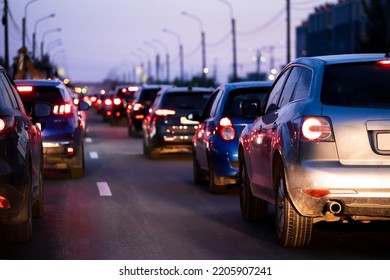 Background, Blur, Out Of Focus, Bokeh. Traffic Jams During Rush Hours After Work. Red Brake Lights Of Stopped Cars On The Background Of The City Neighborhood.