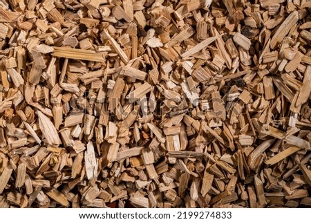 Background of brown dry wood splinter. Wooden chips and slivers. Crushed, chopped wood tree for burning in kiln in winter. Biofuel, lumber. Wooden material. Small pieces of firewood close up. Top view