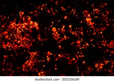 background of burning and glowing hot coals. smoldering embers of fire. flicker of burning coals at night