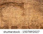 Background - Carved ancient Egyptian writing or hieroglyphics-sacred carvings or mdju netjer meaning words of the gods - in horizontal rows - damaged and grunge