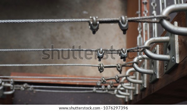 Background\
of chain cable pulleys.  Steel cable\
fences.